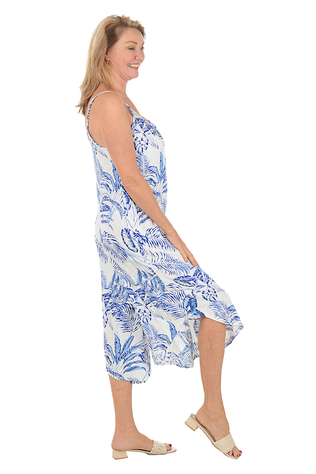Woman wearing a blue and white floral dress on a white background. Side shot.