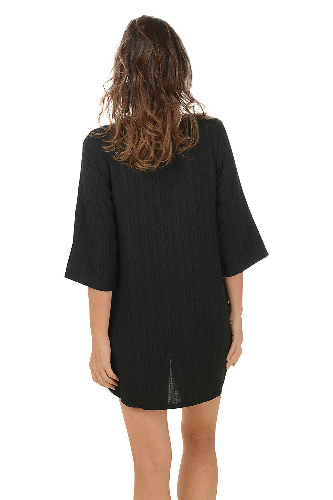 A back shot of a model wearing a black 3/4 sleeve tunic cover-up with lace-up v-neckline and dual hip pockets.