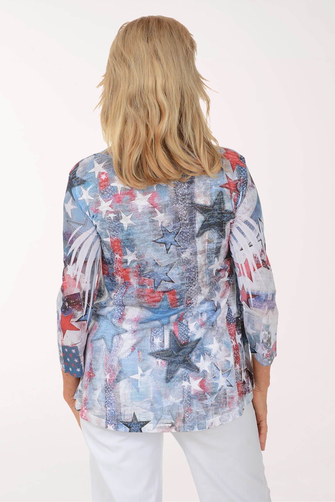 Woman wearing a colorful star-patterned blouse against a white background