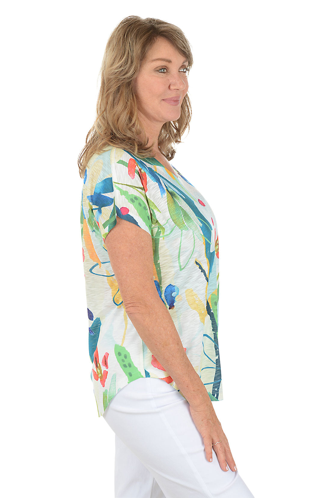 Woman wearing a white short sleeve v-neck shirt with a floral design. Side shot.