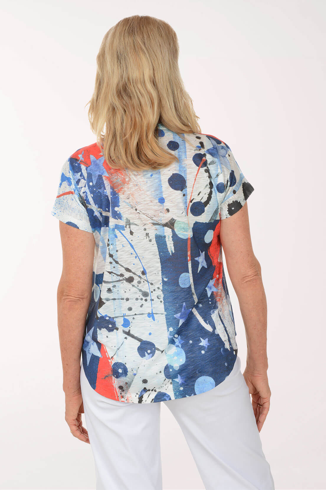 Woman wearing a colorful abstract patterned top on a white background