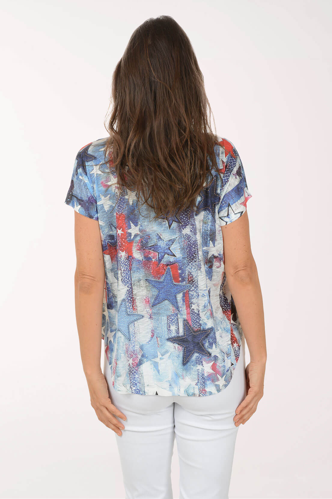 Woman wearing a colorful star-patterned top on a white background