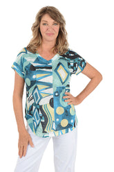 A woman wearing a blue multi colored short sleeve v-neck shirt with an abstract design.