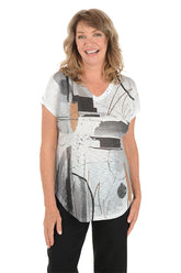 A woman wearing a black and white short sleeve v-neck shirt with an abstract design.