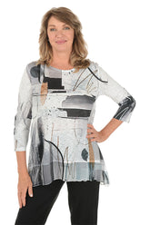 A woman wearing a 3/4 sleeve black and white shirt with an abstract pattern and flutter hem.