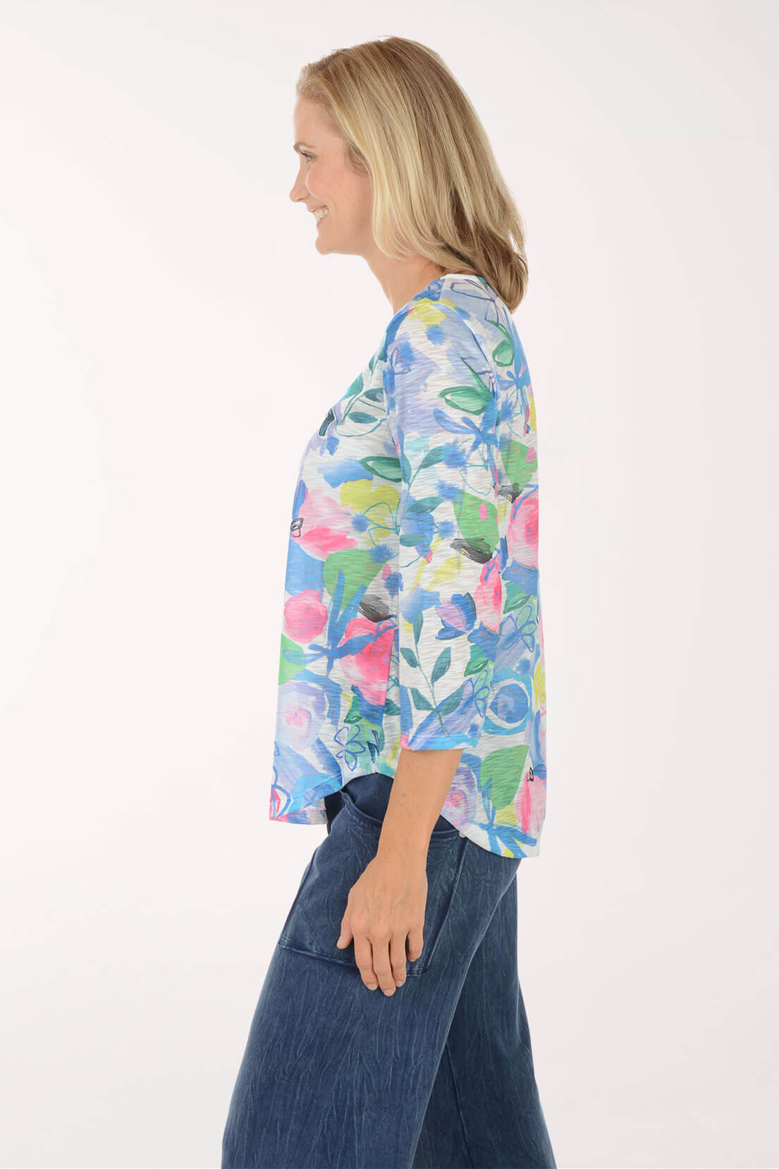 Side view showing the 3/4 sleeve and the curved hem falling just past the hip, with the floral print wrapping around to the back.