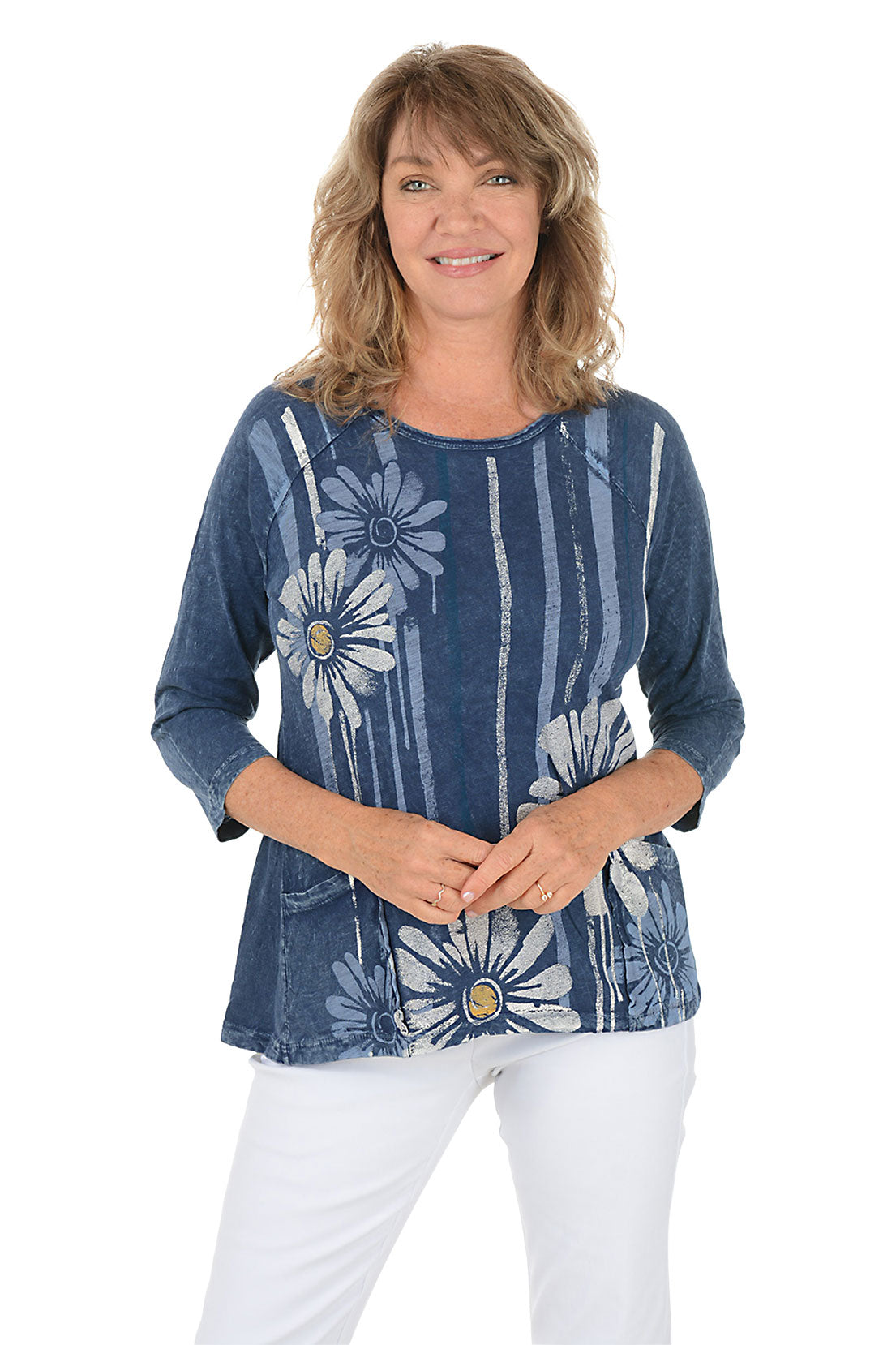 A woman wearing a blue 3/4 sleeve shirt with a daisy pattern.