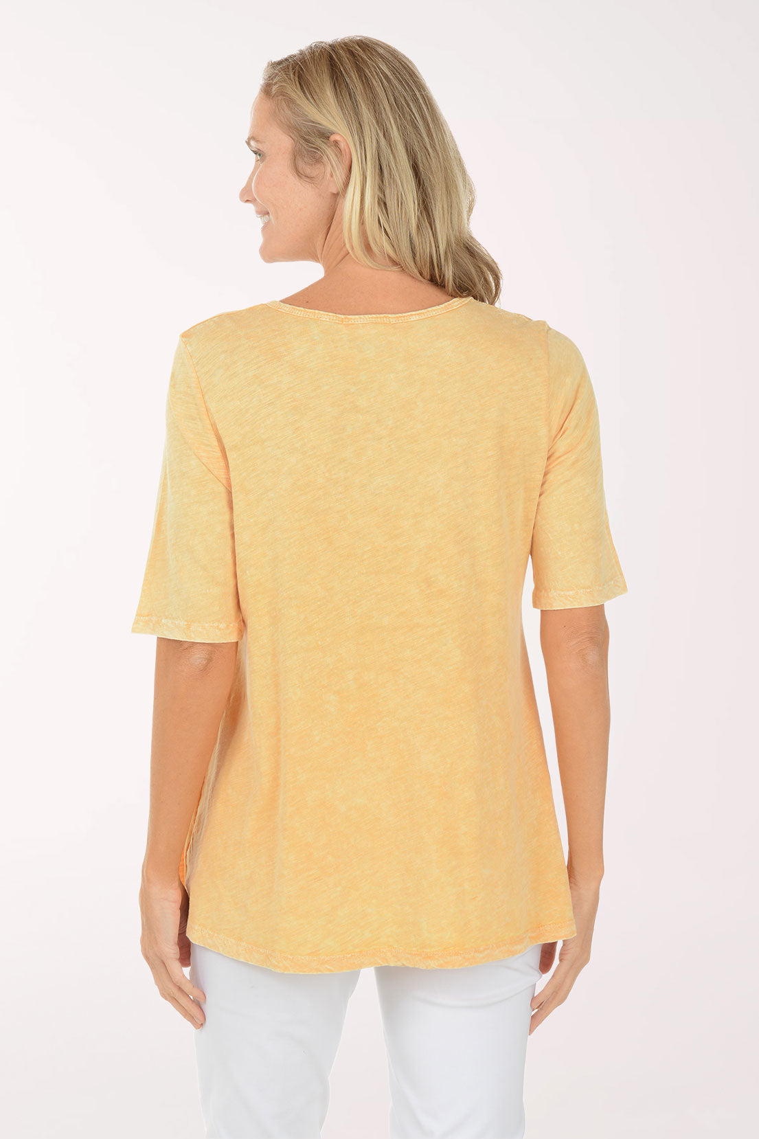 Woman wearing a yellow t-shirt with floral design on a white background