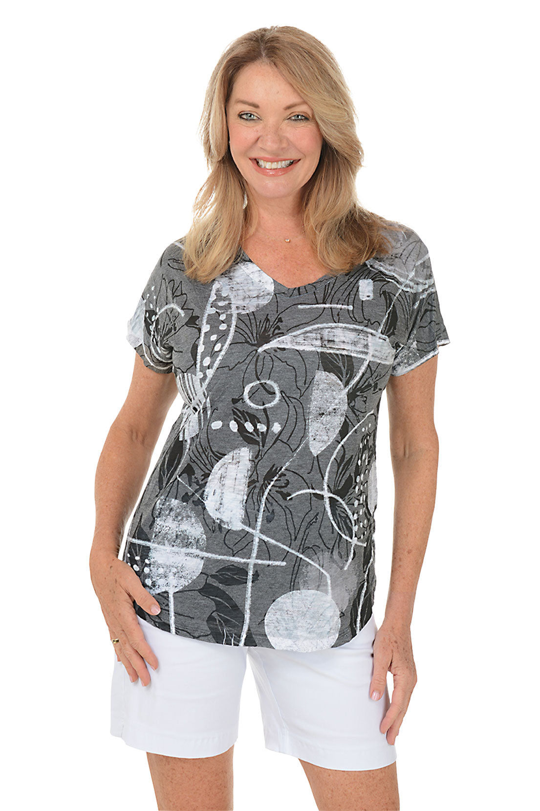 A woman wearing a black and white short sleeve top with an abstract print.
