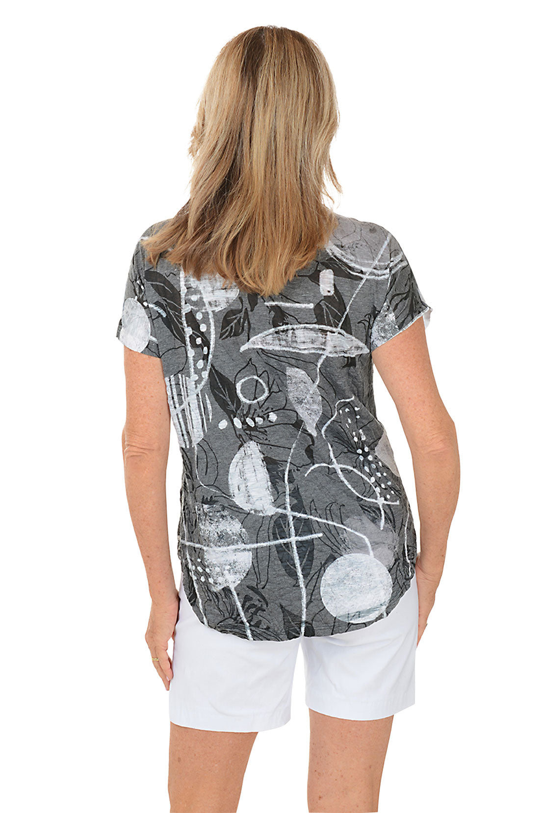 A woman wearing a black and white short sleeve top with an abstract print. Back shot.