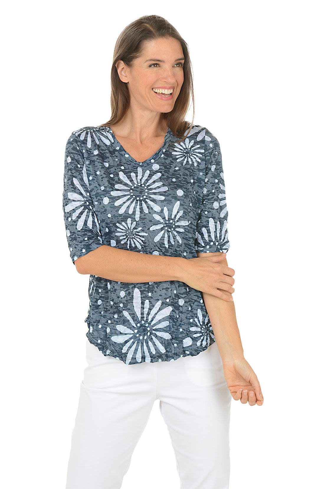 Woman wearing a blue floral patterned top on a white background.