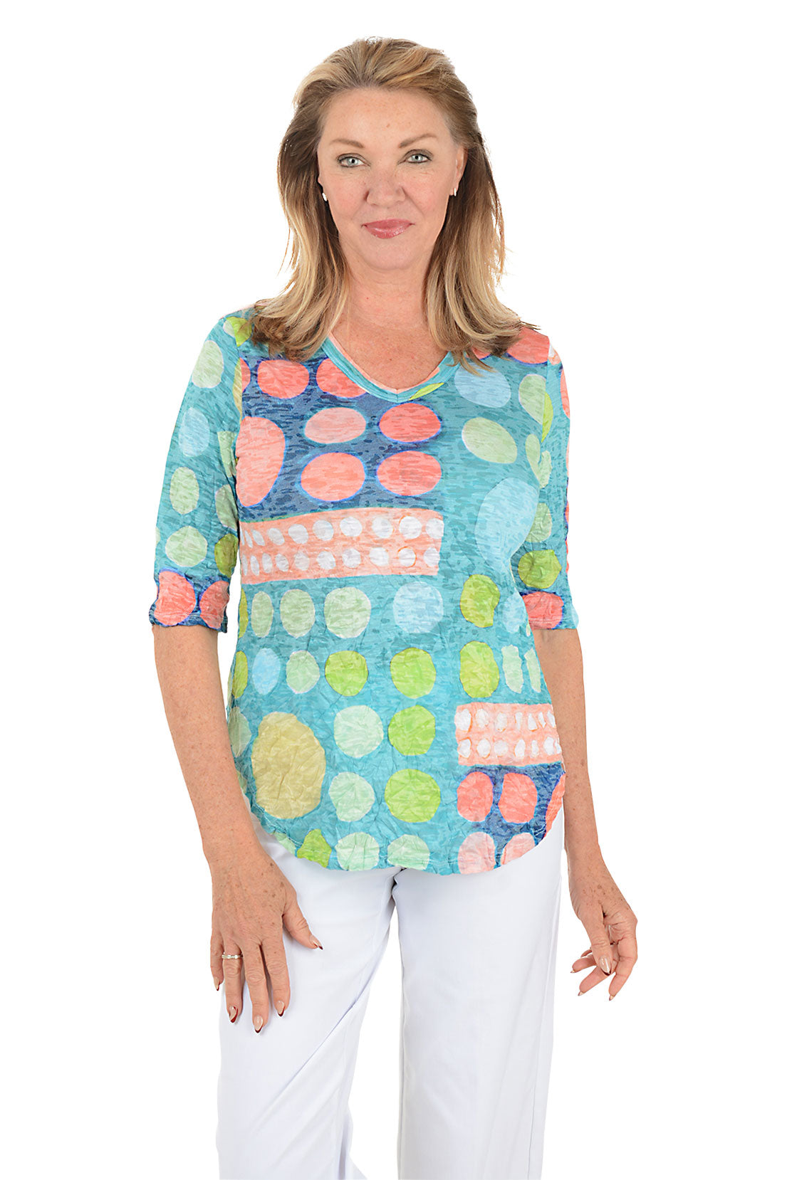 Woman wearing a colorful patterned top on a white background.