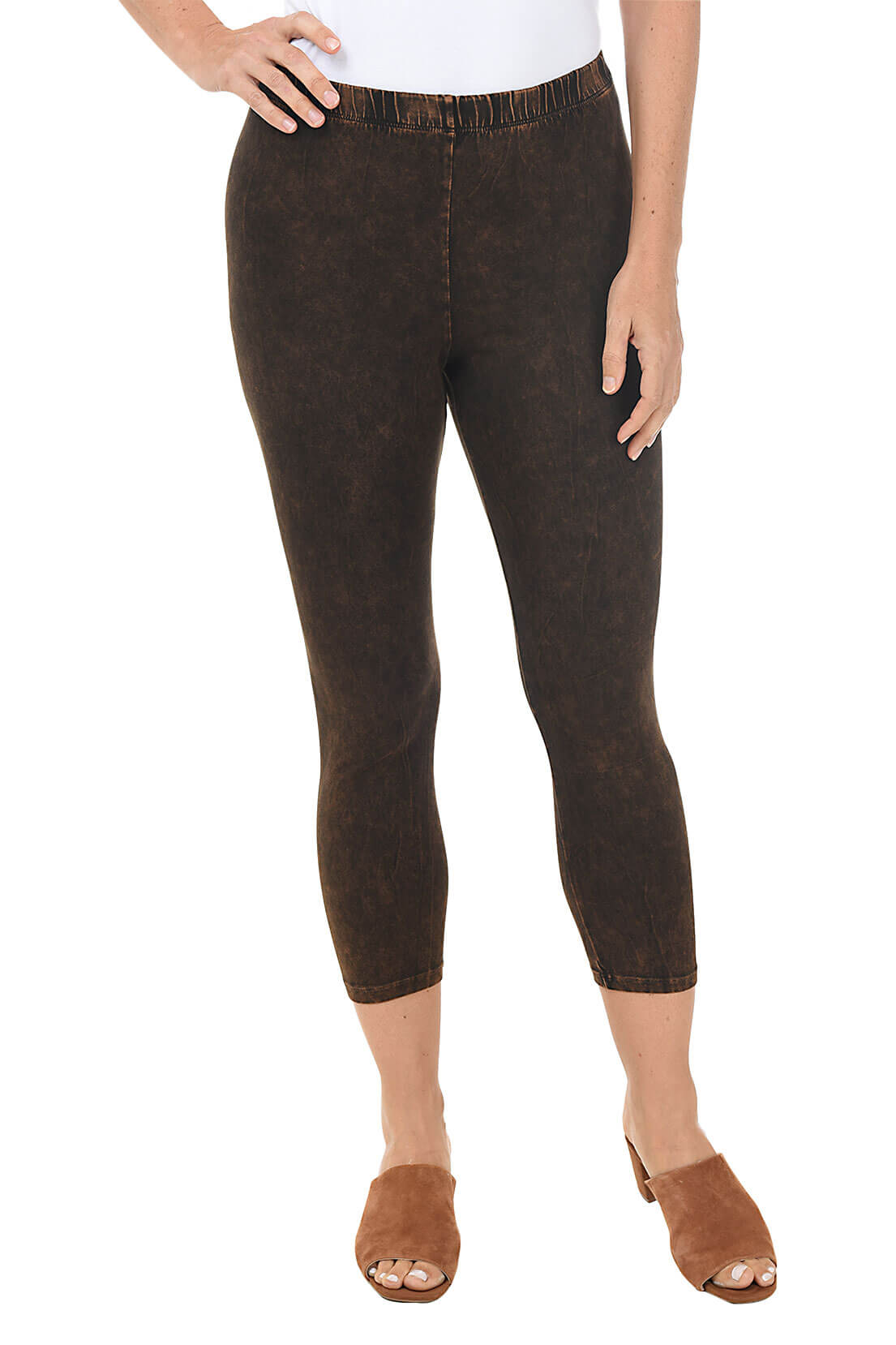 A front shot of a model wearing a pair of chocolate mineral wash capri leggings with an elastic waistband, made from stretchy cotton fabric.