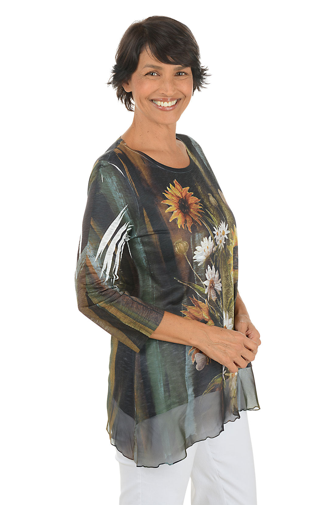 A side shot of a model wearing a floral print top with sunflowers and white flowers on a plain background.