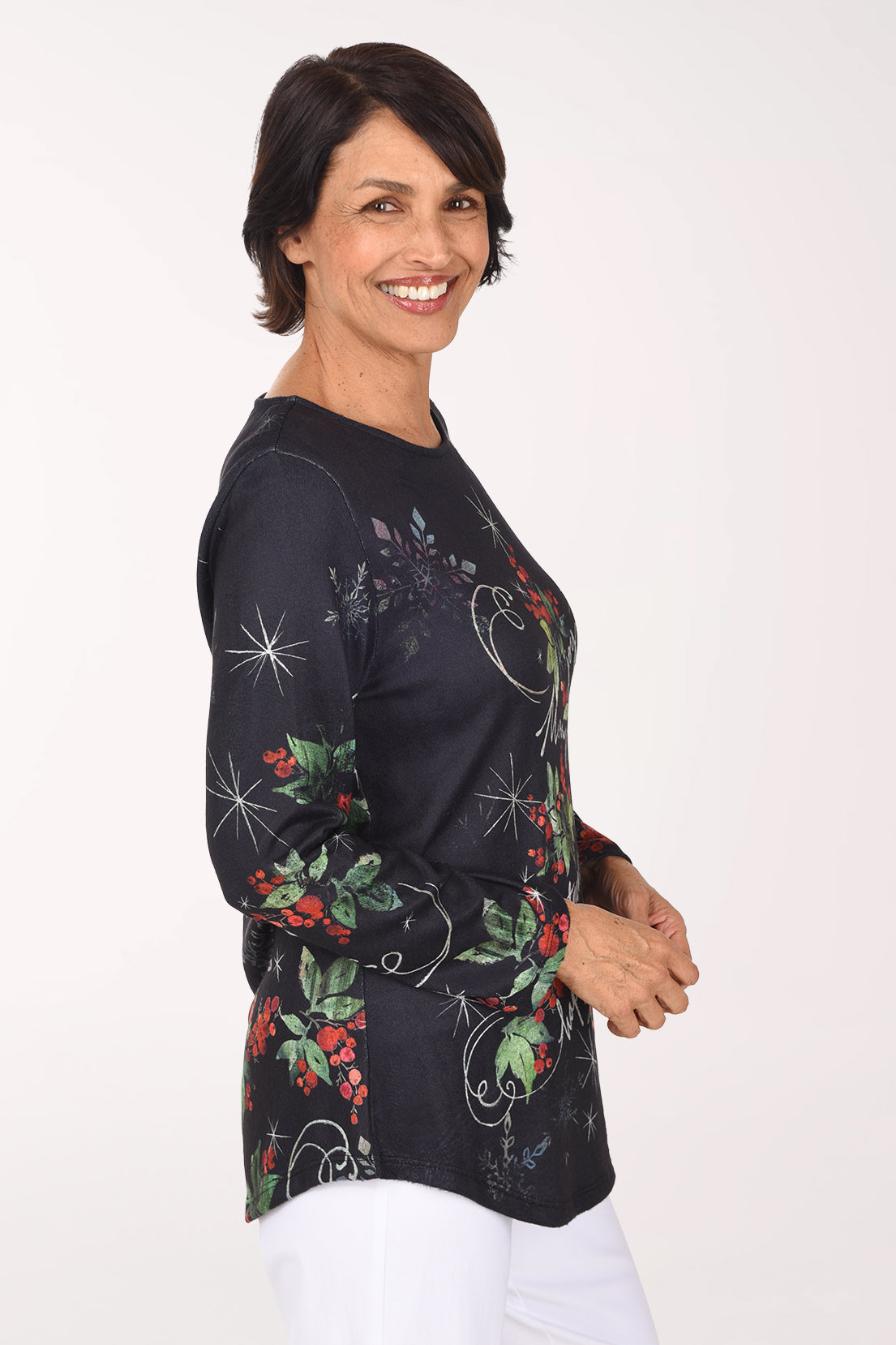 Side view showing the holly and starburst print continuing down the long sleeve and the curved hem