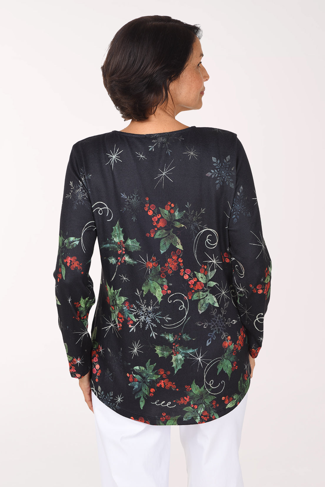 Back view of the black top with holly berries, snowflakes and white swirls printed across the back