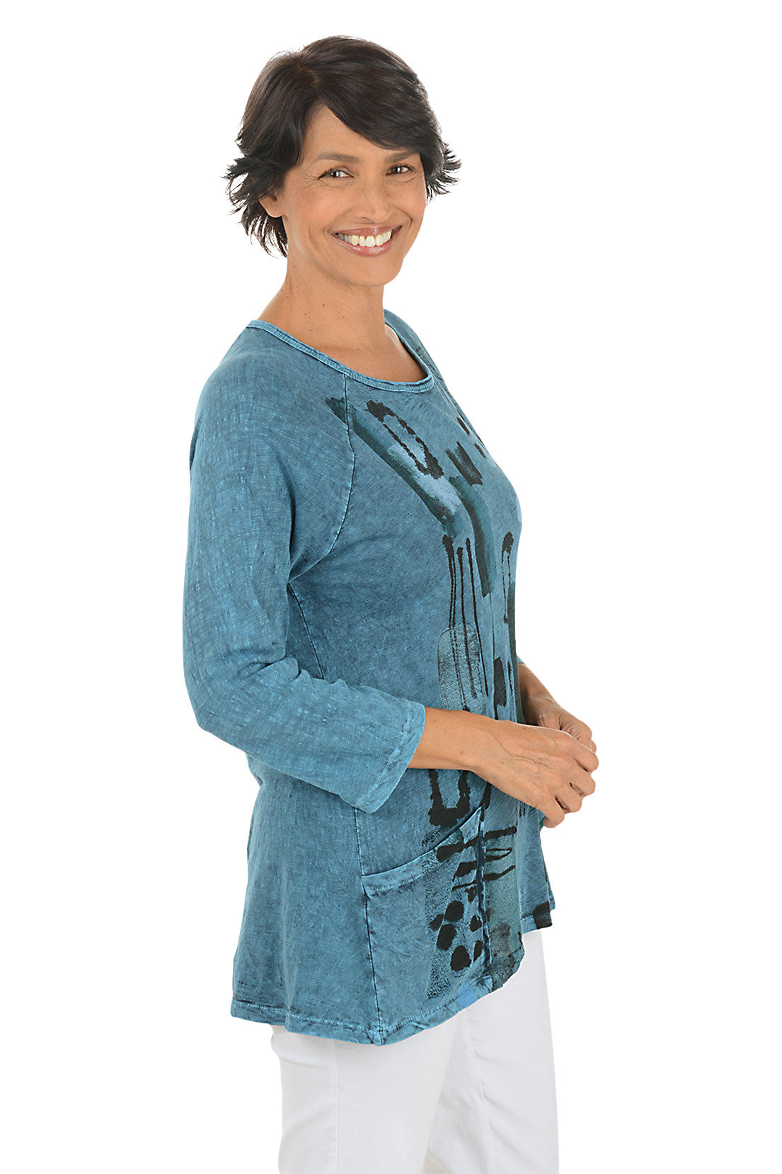 A side shot of a model wearing a blue abstract patterned top on a white background