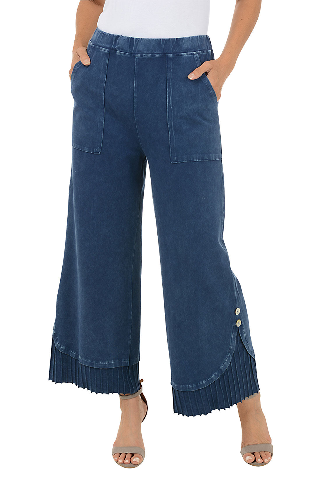 A front shot of a model wearing a pair of wide-leg, pleated hem pants with a mineral wash design. The pants have a high waist with a 1 1/2 inch elasticized waistband, dual front patch pockets, and a double button embellishment at the pleated hemline.