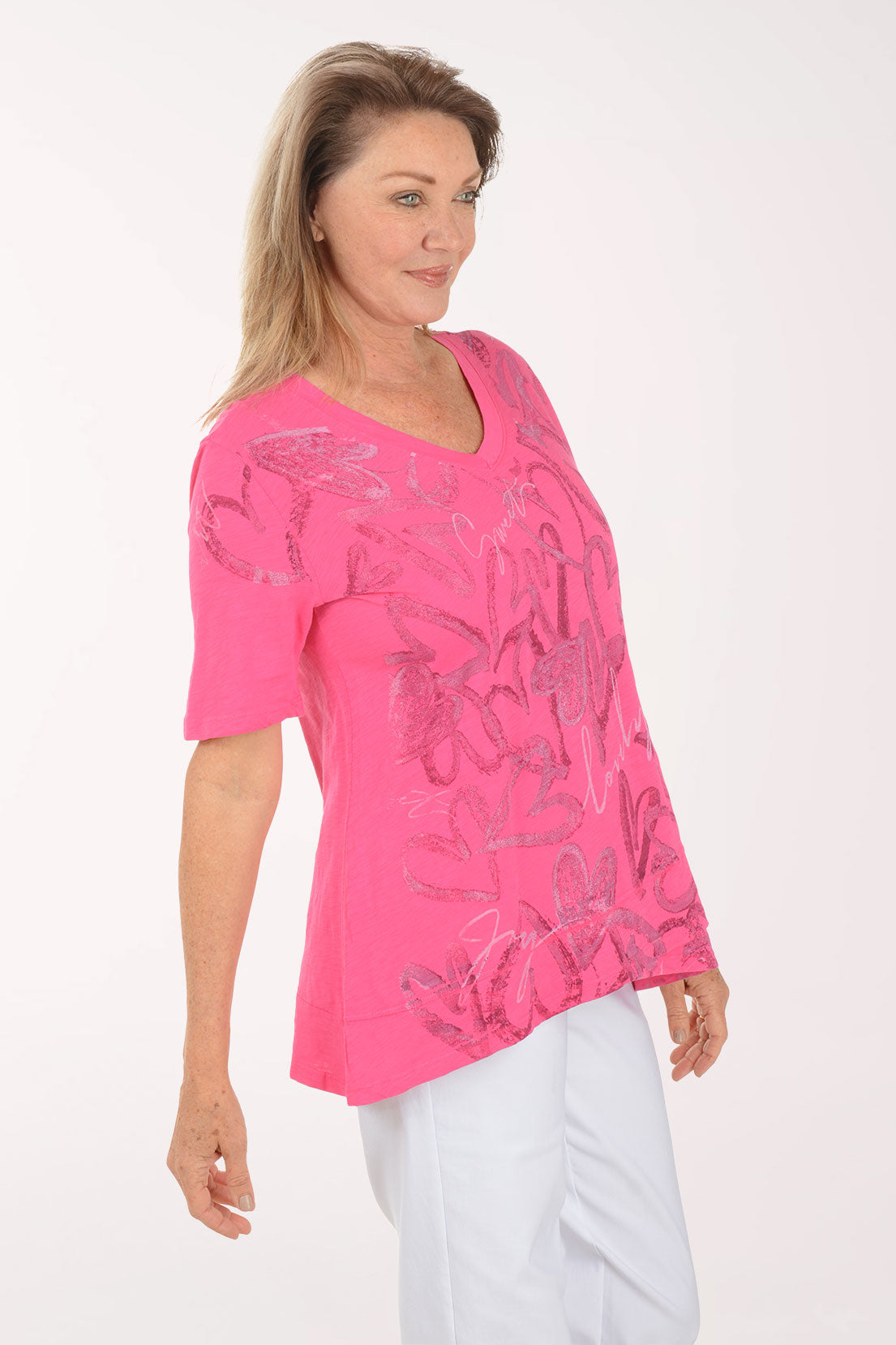 Woman wearing a pink blouse with floral patterns on a white background