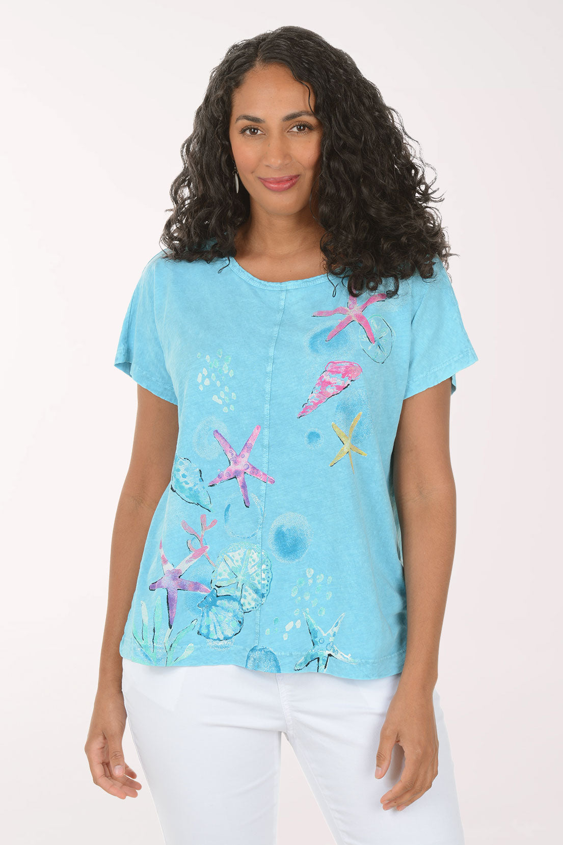 Woman wearing a blue t-shirt with colorful starfish designs on a white background
