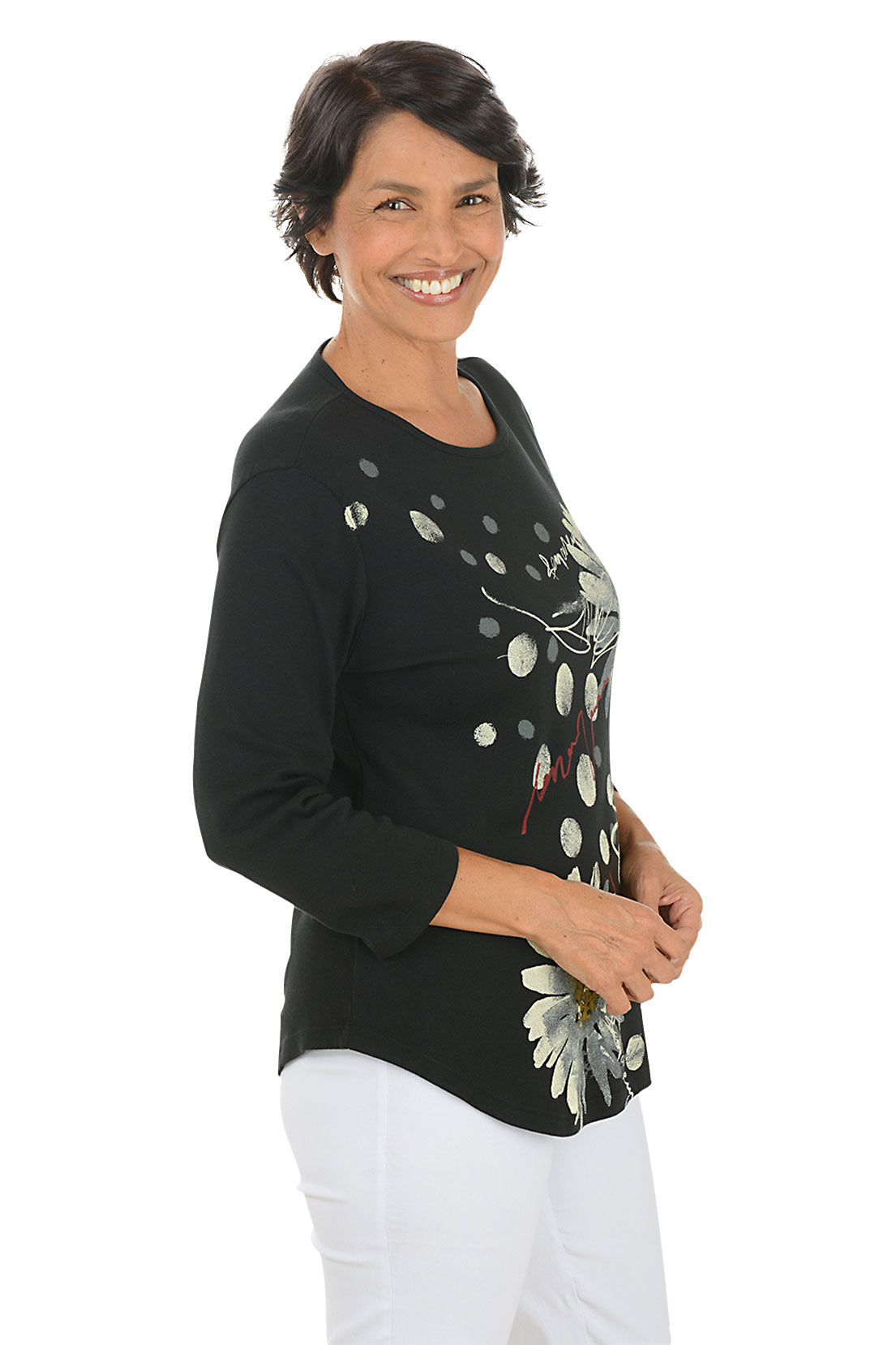 A side shot of a model wearing a black long-sleeve top with floral designs on a white background