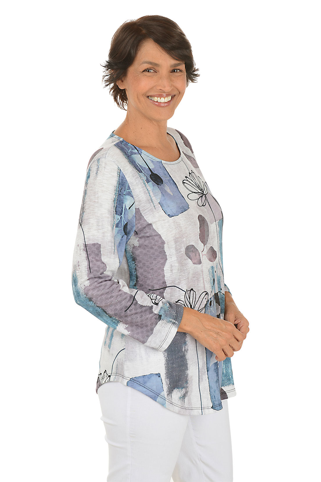 A side shot of a model wearing a colorful abstract patterned top on a white background