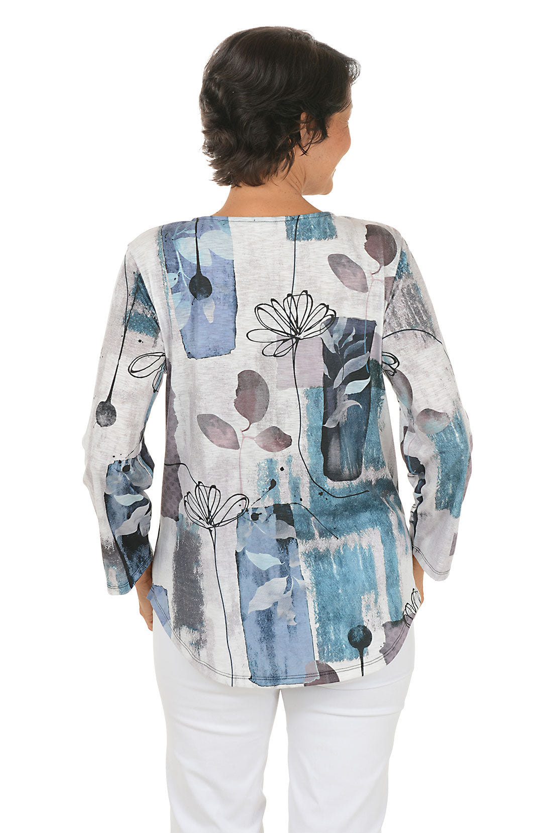 A back shot of a model wearing a colorful abstract patterned top on a white background