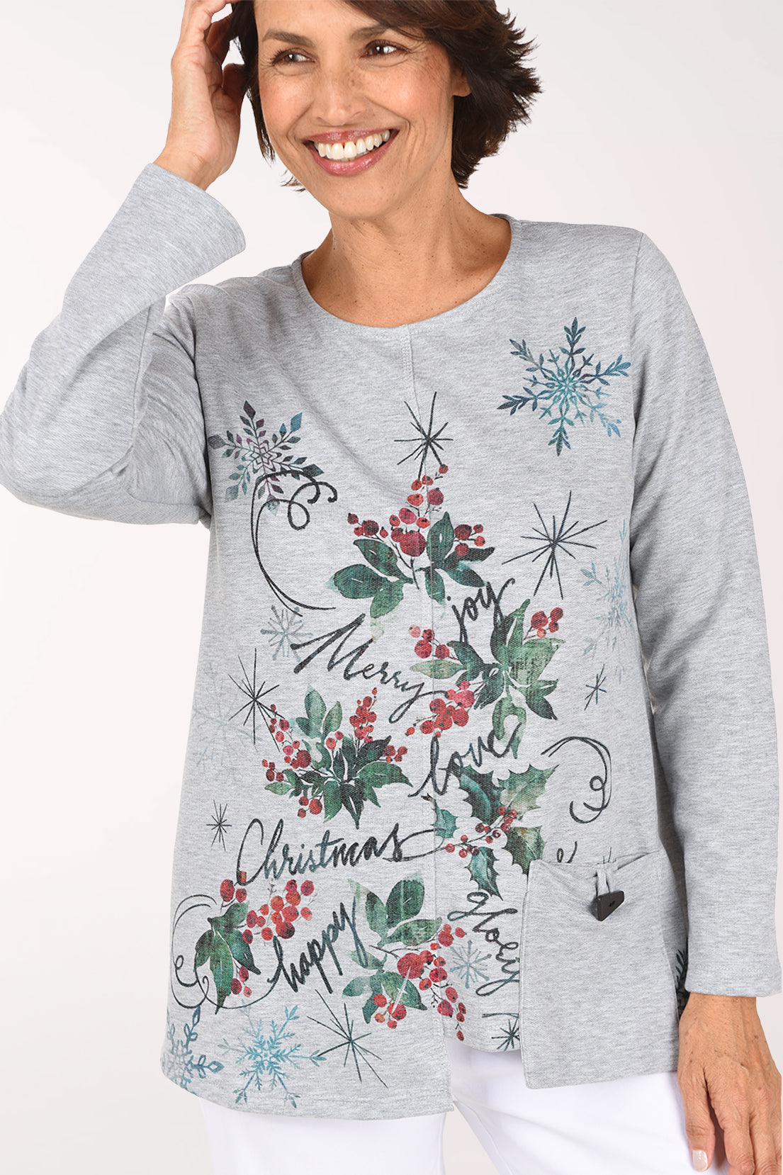 Close front view of the grey fleece top, showing the holly and snowflake artwork, center front seam and hip pocket with a black toggle button