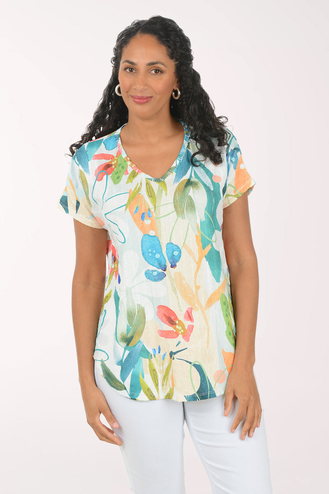 Woman wearing a colorful floral blouse against a white background