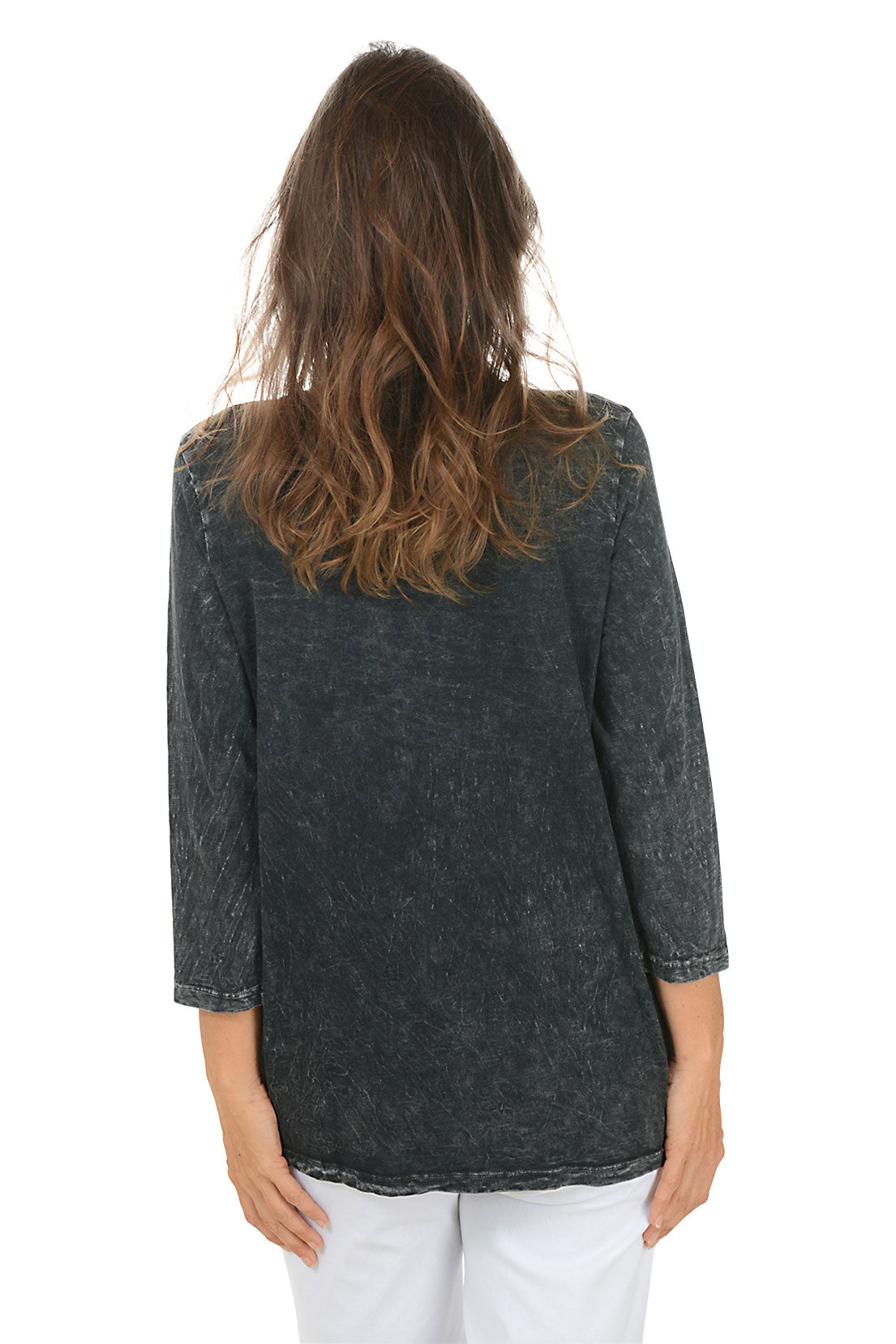 Woman wearing a dark denim shirt with floral embroidery on a white background. Back shot.