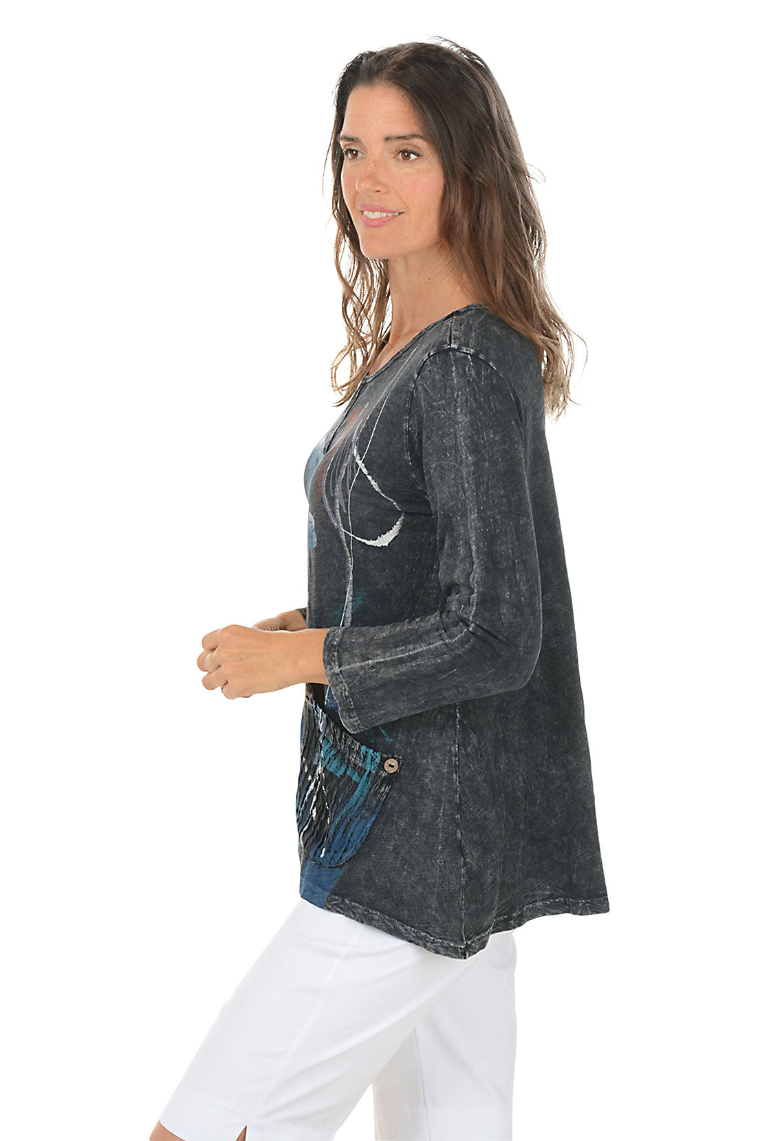 Woman wearing a dark denim shirt with floral design on a white background. Side shot.