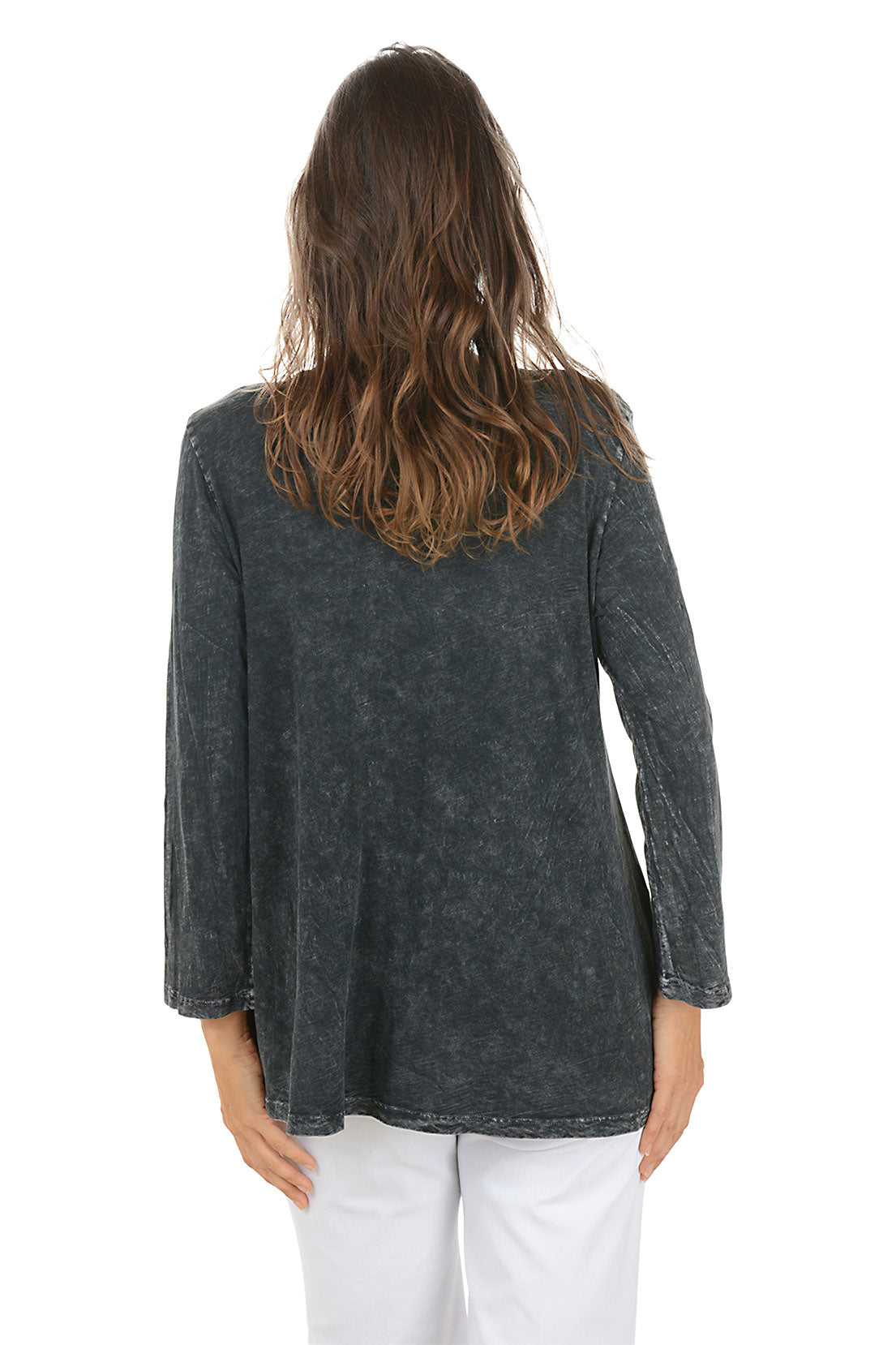 Woman wearing a dark denim shirt with floral design on a white background. Back shot.