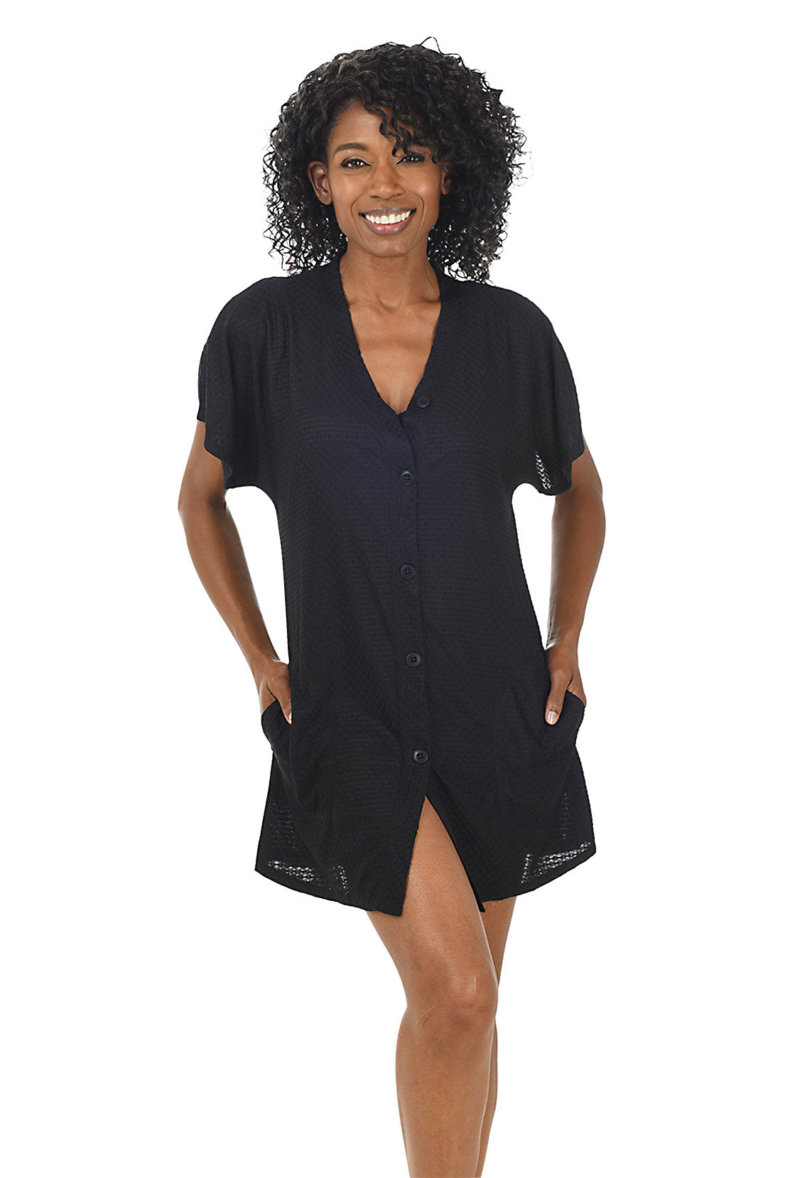 A front shot of a model wearing a black waffle-knit button-front swim cover-up with short dolman sleeves and a V-neckline.