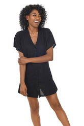 A front shot of a model wearing a black waffle-knit button-front swim cover-up with short dolman sleeves and a V-neckline.