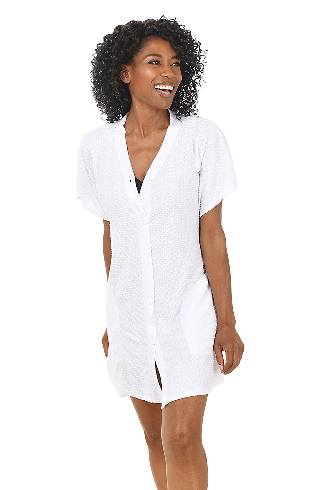 A front shot of a model wearing a white waffle-knit button-front swim cover-up with short dolman sleeves and a V-neckline.