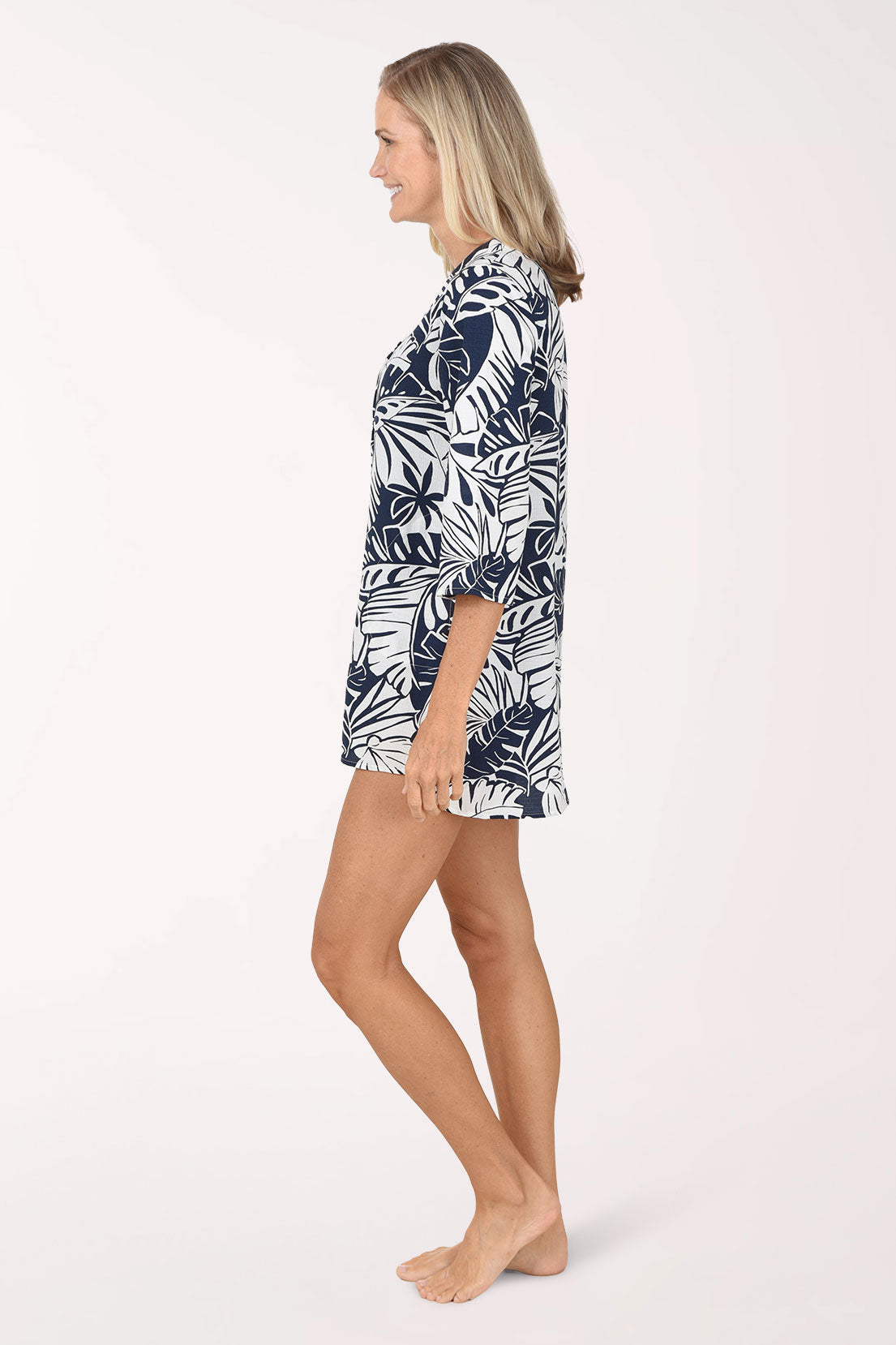 A side view of the navy and white palm leaf tunic cover-up showing the curved high-low hem.