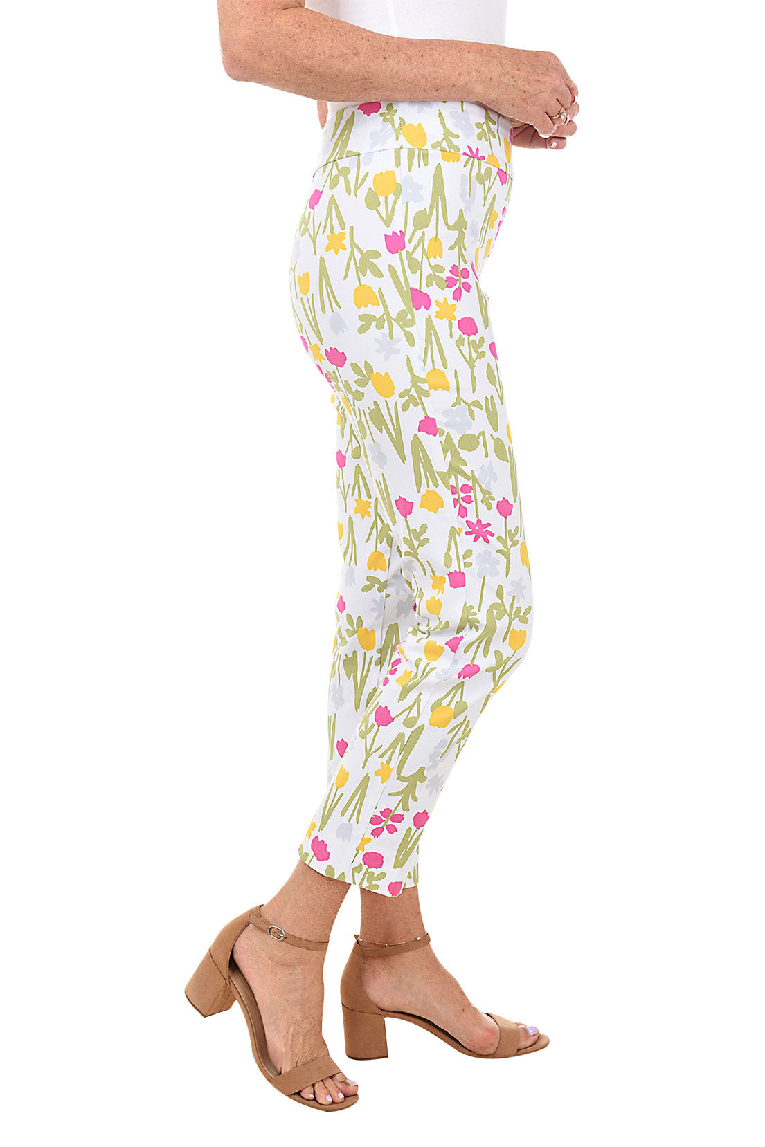 A side shot of a model wearing a pair of pull-on ankle pants with a floral pattern, elasticized waistband, and tummy control liner.