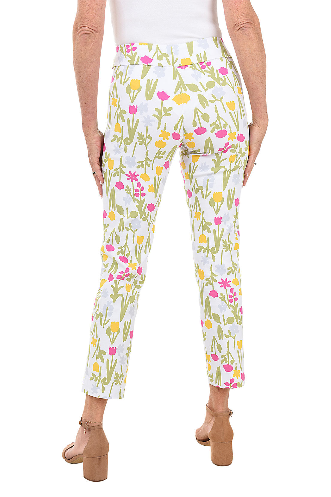 A back shot of a model wearing a pair of pull-on ankle pants with a floral pattern, elasticized waistband, and tummy control liner.
