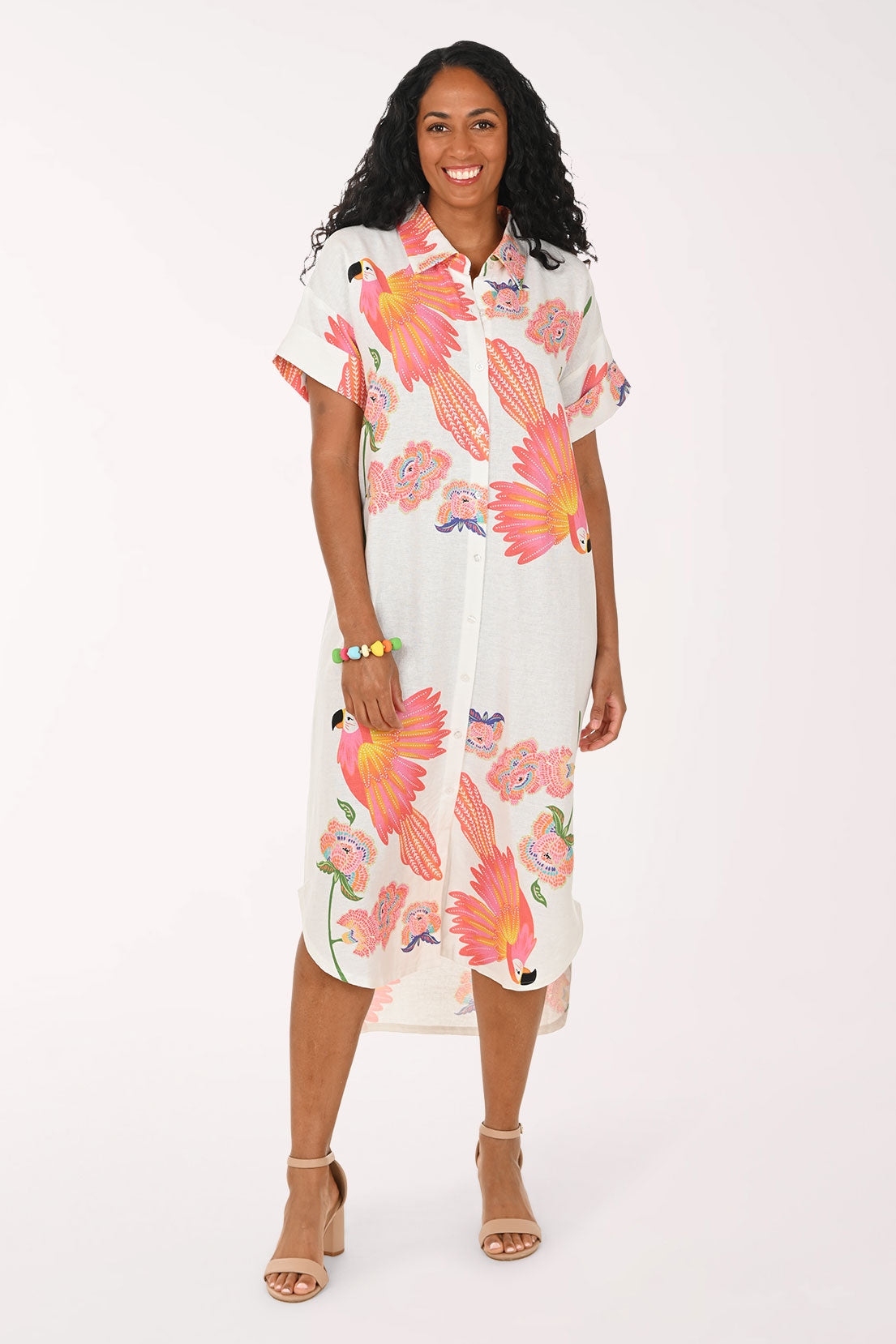 Woman wearing a white multi dress with a parrot print.