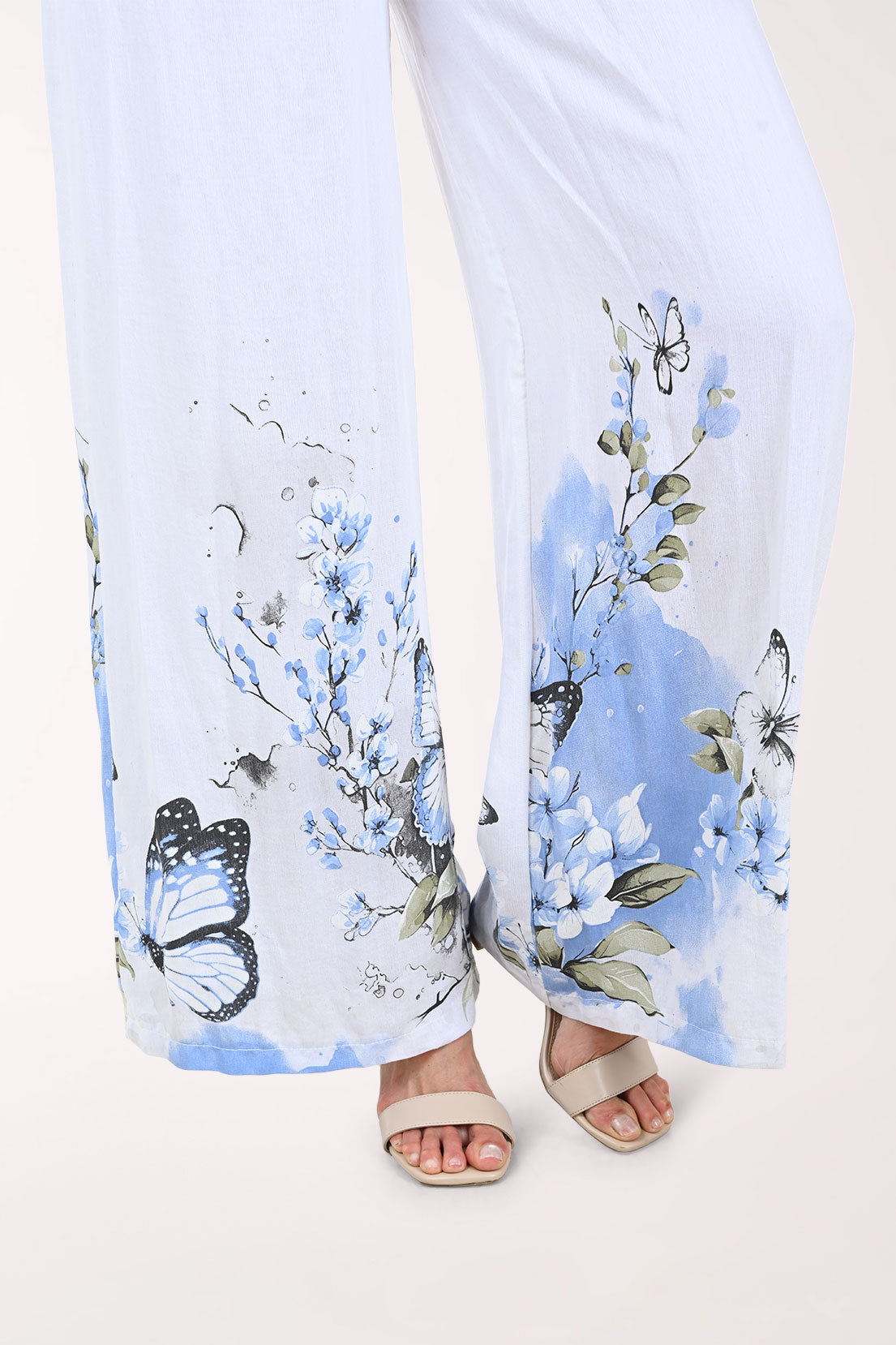 White pants with blue butterfly pattern worn by a person on a white background