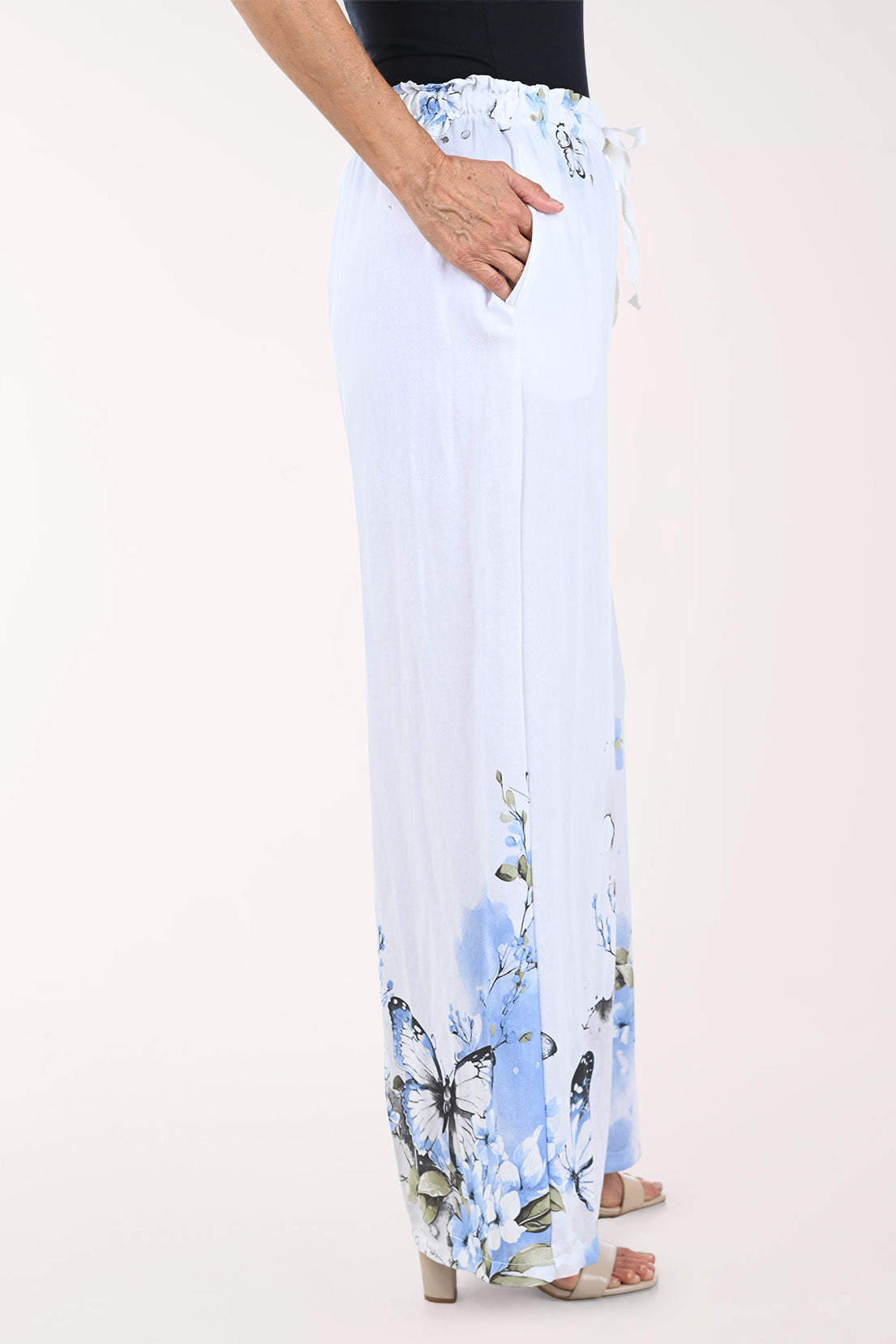 White pants with blue butterfly pattern worn by a person on a white background