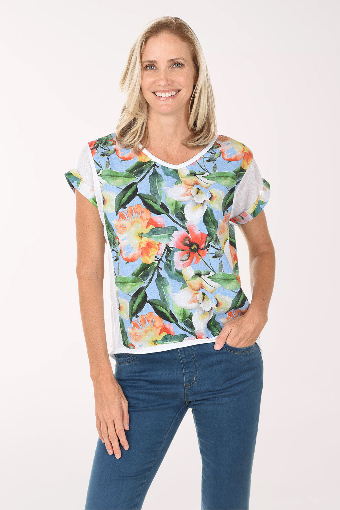 Woman wearing a colorful floral t-shirt and blue jeans on a white background