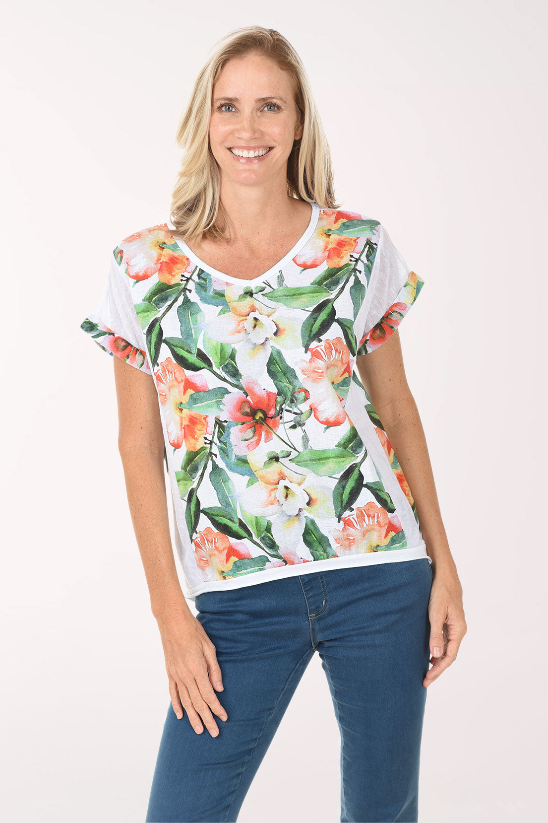Woman wearing a white t-shirt with floral design and blue jeans on a white background