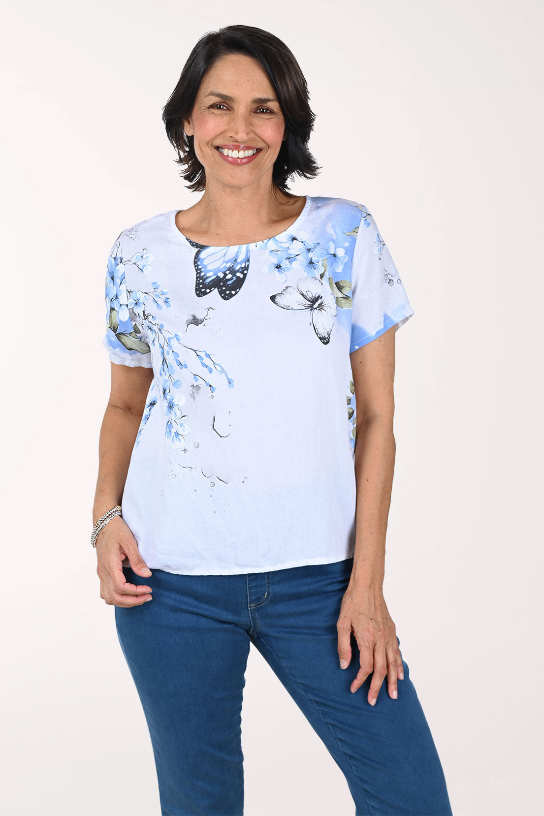 Woman wearing a light blue t-shirt with butterfly design on a white background