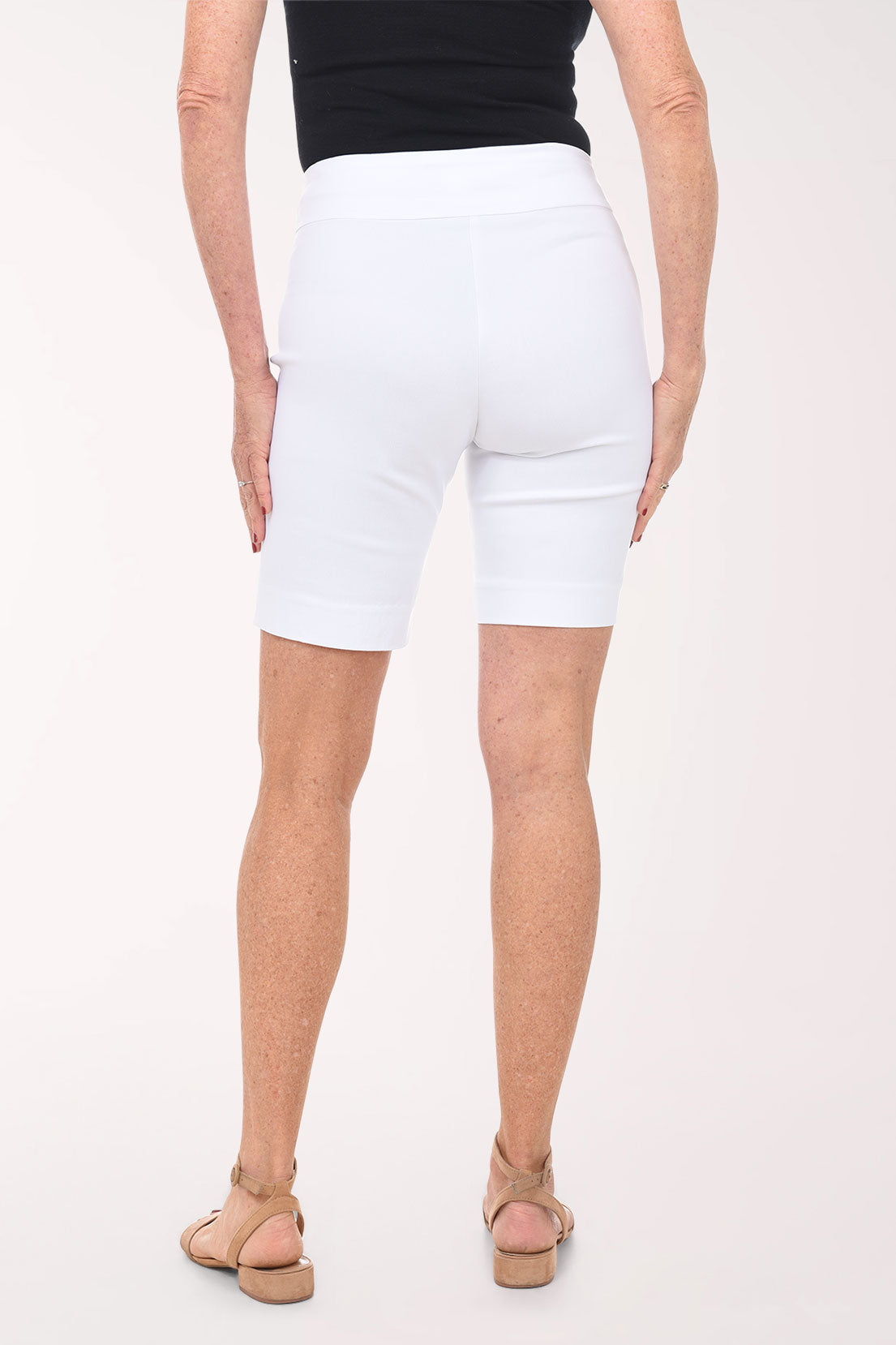 Person wearing white shorts on a plain background