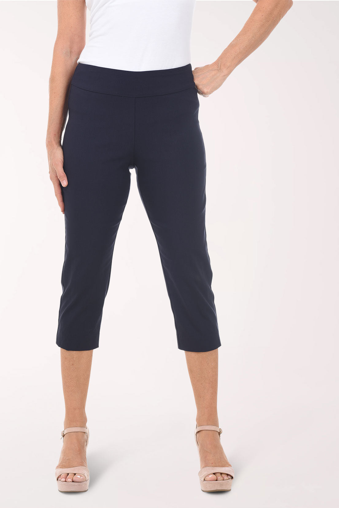 Person wearing navy capri pants on a white background