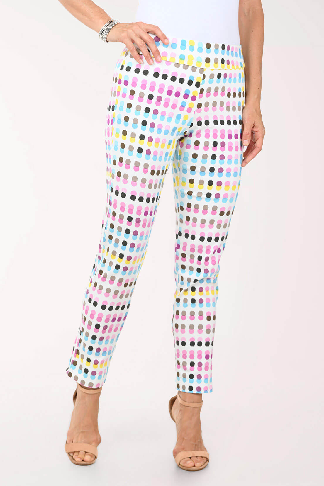 Multicolored polka dot pants worn by a person on a white background