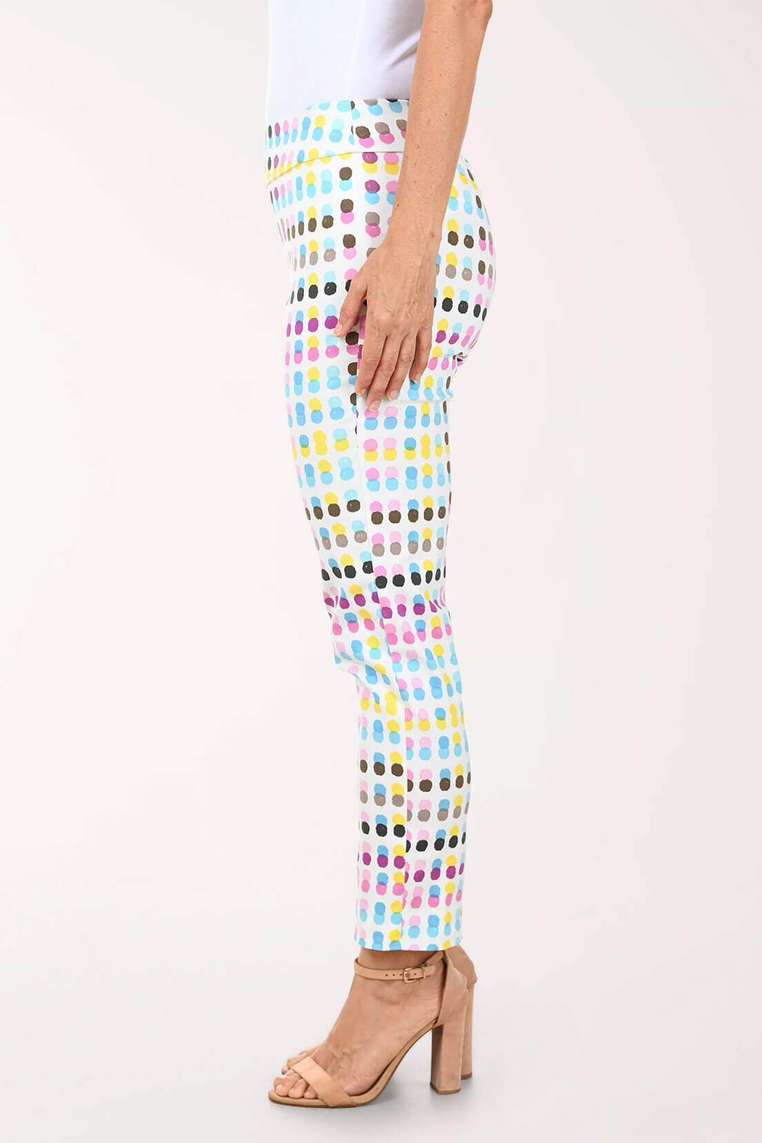 Multicolored polka dot pants worn by a person on a white background