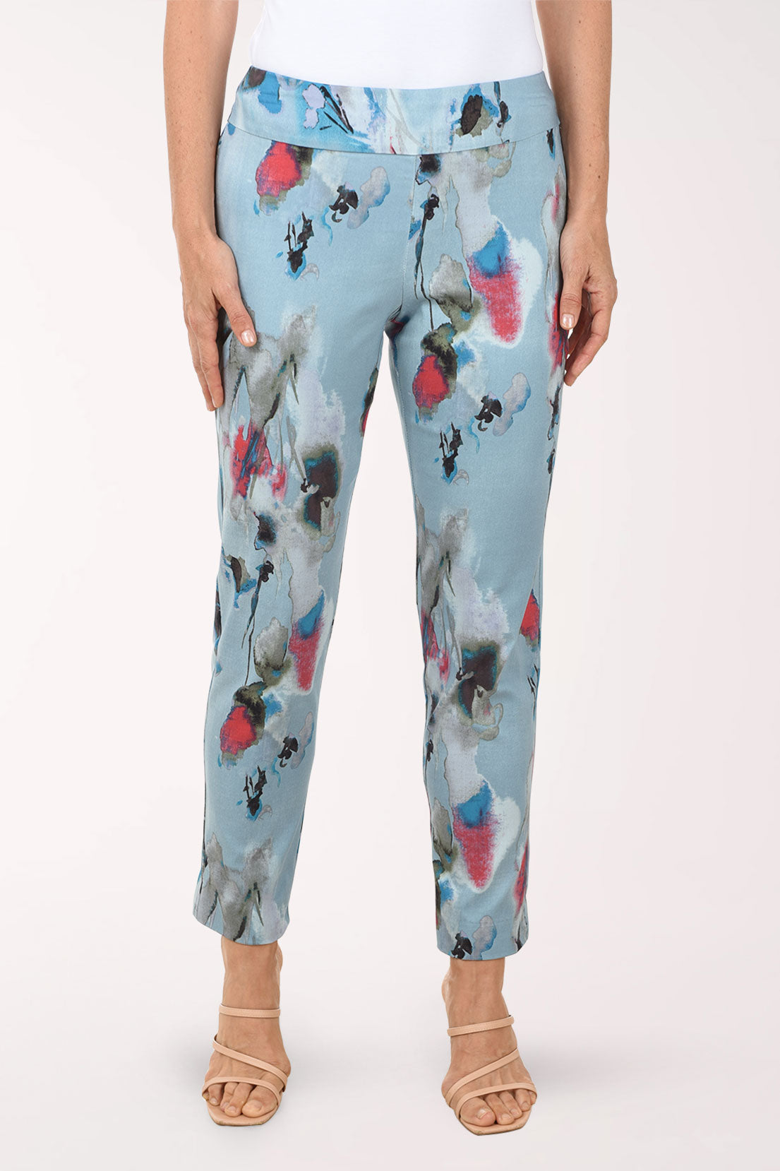 Light blue pants with colorful floral pattern worn by a person on a white background