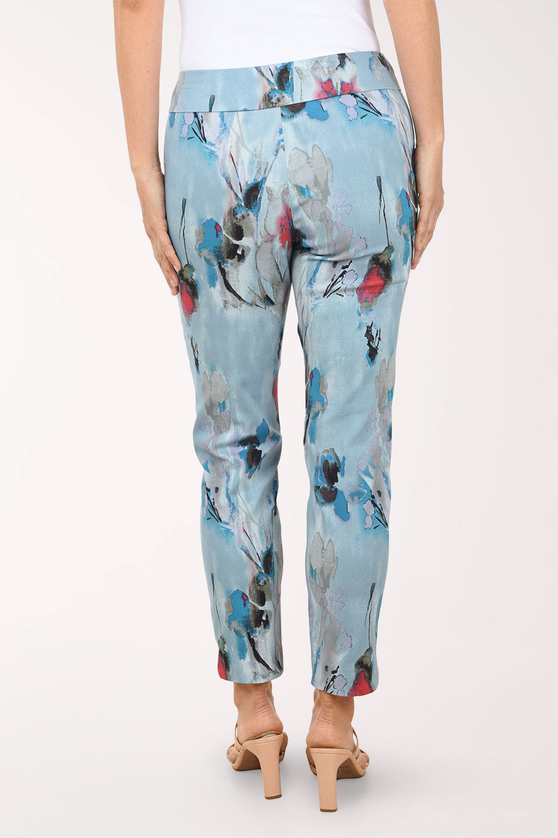 Light blue pants with colorful floral pattern worn by a person on a white background